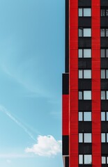 A tall building with red and black walls against the blue sky 