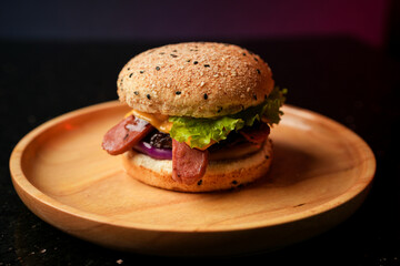 Burger served on a wooden plate with sausage, patty, lettuce, onion, and tomato. social media post, food photography, fine dining, purple background, restaurant menu, fast food, junk food, street food