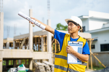 An architect, wearing a hardhat and safety vest, checks a laptop and house plan paper on a clipboard. Blueprints and construction documents lie nearby, emphasizing safety and precision in building.