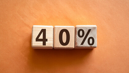 Wooden cubes with text 40% on orange backdrop. Wood blocks, number percent. Close-up. Flat lay