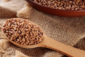 Wooden Spoon with Raw Buckwheat on Burlap, Close-Up