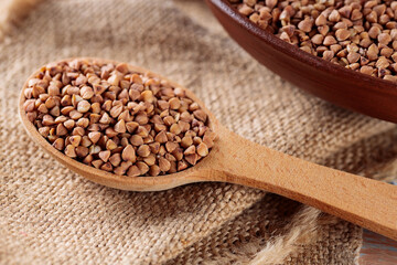 Wooden Spoon with Raw Buckwheat on Burlap, Close-Up