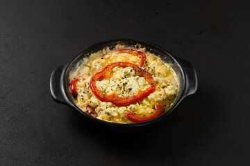 Closeup view of grilled feta cheese with fresh tomato, bell pepper and oregano in plate.