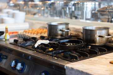 A stove top with two pots on it, one of which is black and the other is silver