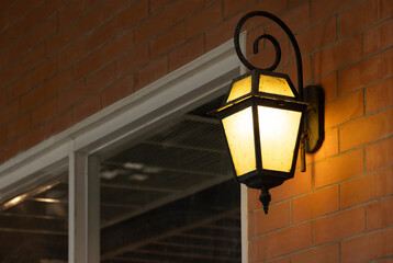 A lamp hanging from a brick wall