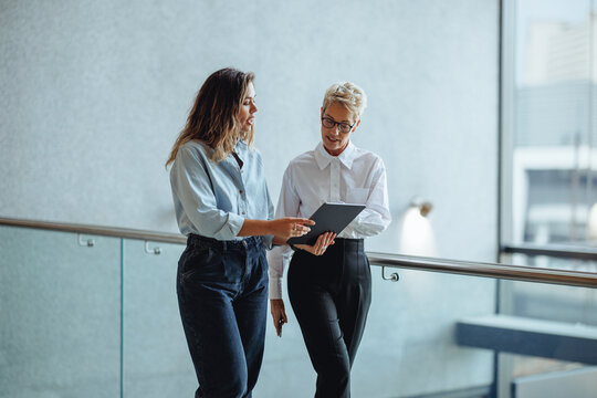 Mature business woman discussing her schedule with her executive assistant in an office
