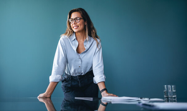 Happy business woman standing in the meeting room of a finance company