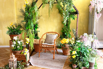 Interior of a wooden greenhouse with rattan chair. Plants and flowers growing in small wooden greenhouse. Wooden rustic arch style, different garden tools and pots. Gardening at home. Wedding decor	

