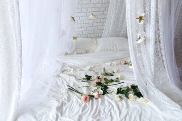 Roses on bed in room. Bedroom interior design. Closeup of bed with scattered pink and white roses. Bed with flowing curtains and garland flowers levitating, hanging flowers. Honeymoon. Valentine day   © stock_studio