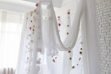 White lace texture curtains with floral abstract pattern with spring flowers levitate. Summer pink peonies flowers levitating, hanging flowers on a white background, copy space. Template, mockup.   © stock_studio