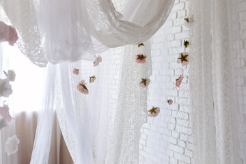 Baldachin on bed. Summer pink peonies and roses flowers levitating, hanging flowers, copy space. Template, mockup. White lace curtains canopy with floral abstract pattern with spring flowers levitate  © stock_studio