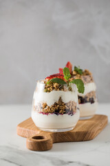 Yogurt with crispy granola, berries and mint leaves for a delicious breakfast. Healthy eating.