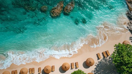 Fototapeta premium Aerial view of a beautiful tropical beach with clear turquoise water, sandy shore, beach chairs, and umbrellas. Perfect vacation paradise.