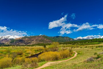 Scenic view of a green valley and mountains under a blue sky. Rocky Mountain National Park, Colorado