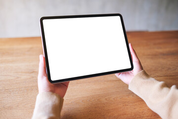 Mockup image of a woman holding digital tablet with blank white desktop screen