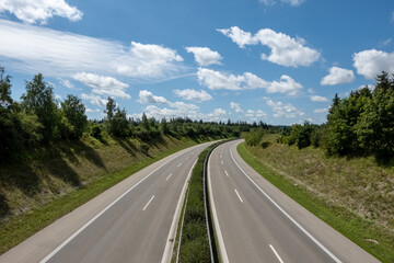 4 lane highway road at countryside against blue sky with fair weather clouds