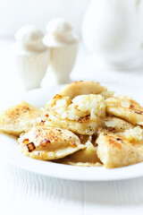 Dumplings with potato and cottage cheese stuffing (pierogi). Traditional Polish Christmas Dinner. Bright background.
