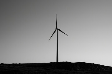 A clean, minimalistic photo of a wind turbine silhouette against a clear sky, representing renewable energy
