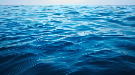 A serene scene capturing the vast expanse of the blue ocean with gentle ripples creating a calming and tranquil atmosphere, perfect for relaxation and peace.