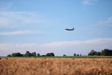 Poland, Europe - 10 07 2024: Low Fares Ryanair Aircraft Flying Before Landing Over Field with Hay Bales