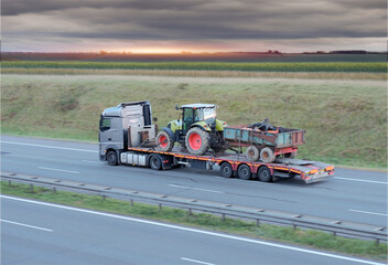 Heavy-Duty Truck Transporting Agricultural Farm Tractor on Intercity Highway