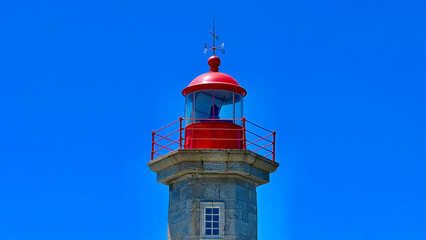 a lighthouse sits on a ledge overlooking the water