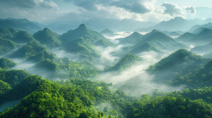 Obraz premium a beautiful landscape of misty mountains. The mountains are covered in lush green vegetation and the clouds are rolling in the valley below. 