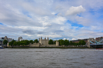 Fototapeta premium View of the the River Thames and the Tower of London, a castle and a former prison in London, England. The Tower of London, today a museum, is a fortified complex that includes multiple buildings