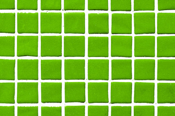 Green square ceramic tile background. Swimming pool texture. Geometric wall decoration. Home bathroom floor. Ornamental patchwork. Simple square design. White fugue grid.