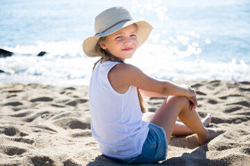 Child in ha enjoying on sandy beach of sea coast