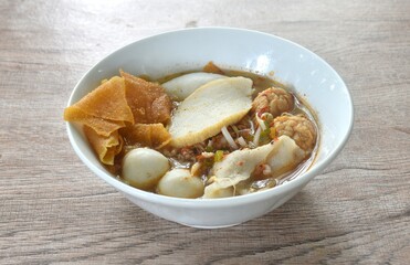 boiled meatball made from fish and shrimp with dumpling  couple bean sprout in spicy tom yum soup on bowl  