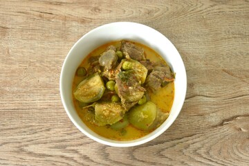 spicy boiled beef meat with eggplant in coconut milk red curry soup on bowl 