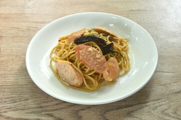 spicy stir fried spaghetti slice pork sausage with dry chili and basil leaf on plate