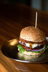 a burger with lettuce, tomato, beef patty, cheese, and onions