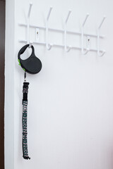Stylish Green and Black Patterned Retractable Dog Leash Hanging on Sleek White Wall Hook