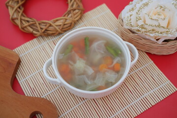 Creamy soup in a white bowl, with delicious side dishes