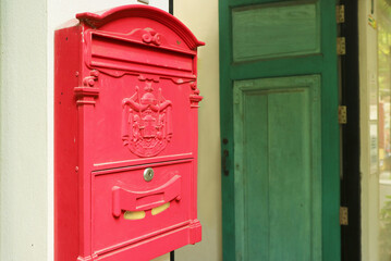 Red Postbox on the Outside Wall of a Vintage House