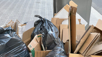 Pile of rubbish and litter on the sidewalk with busy pedestrians walking past