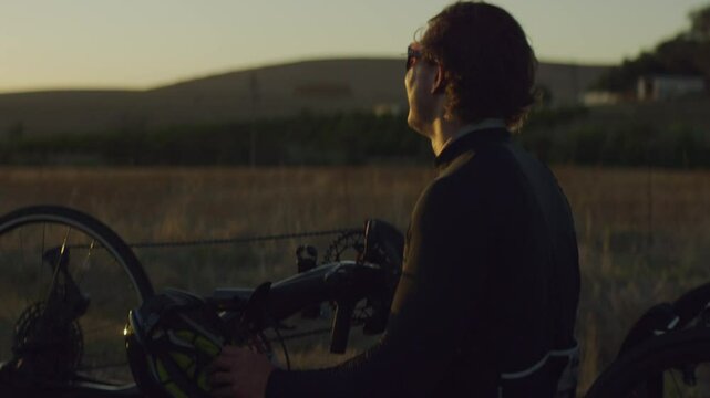 Para Athlete cycling at sunset and smiling