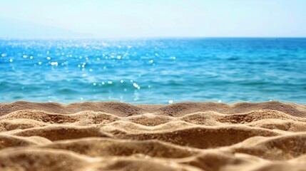 Summer beach background with sand in the foreground and a serene sea in the background, ideal for travel and vacation themes.
