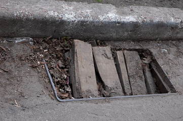 the old storm drain is clogged with boards and last year's leaves