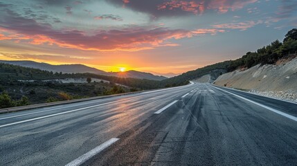 Fototapeta premium Panoramic sunrise view of an asphalt highway with natural mountain scenery, capturing the serene beauty of dawn.