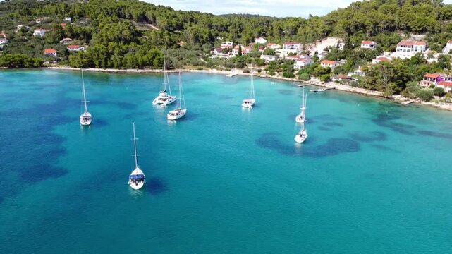 Drone view of yachts moored on buoys near the shore in the bay of Uvala Gradina near the town of Vela Luka on the island of Korcula in Croatia