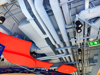 Ceiling with ventilation pipes and lights in industrial building