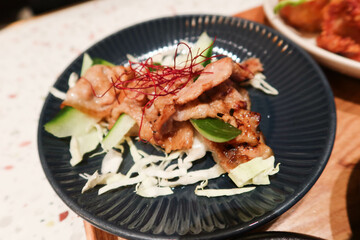 close up of Japanese style stir fried pork on a black plate
