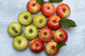 Beautiful green and red apples top view photo. Juicy organic fruit on light grey textured background with space for text. Healthy eating concept. 