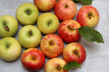 Beautiful green and red apples top view photo. Juicy organic fruit on light grey textured background with space for text. Healthy eating concept. 