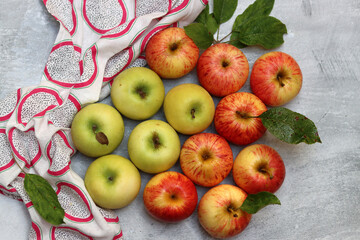 Beautiful green and red apples top view photo. Juicy organic fruit on light grey textured background with space for text. Healthy eating concept. 