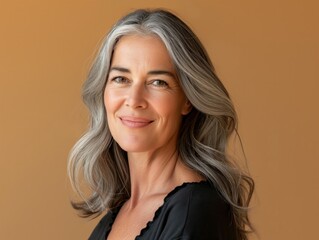 Fototapeta premium Studio portrait of a confident mature woman with grey hair, exuding elegance and natural beauty, ideal for lifestyle and beauty concepts.