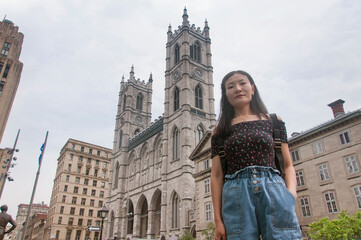 Fototapeta premium chinese woman standing in front of Notre Dame Cathedral Montreal